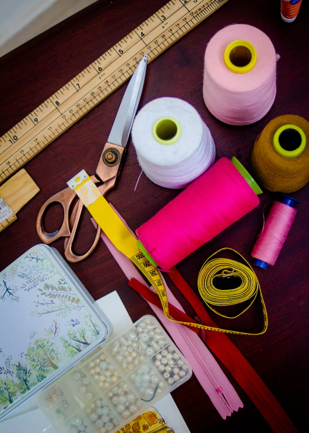 Bobines de fil et ciseaux de couture posés sur un plan de travail